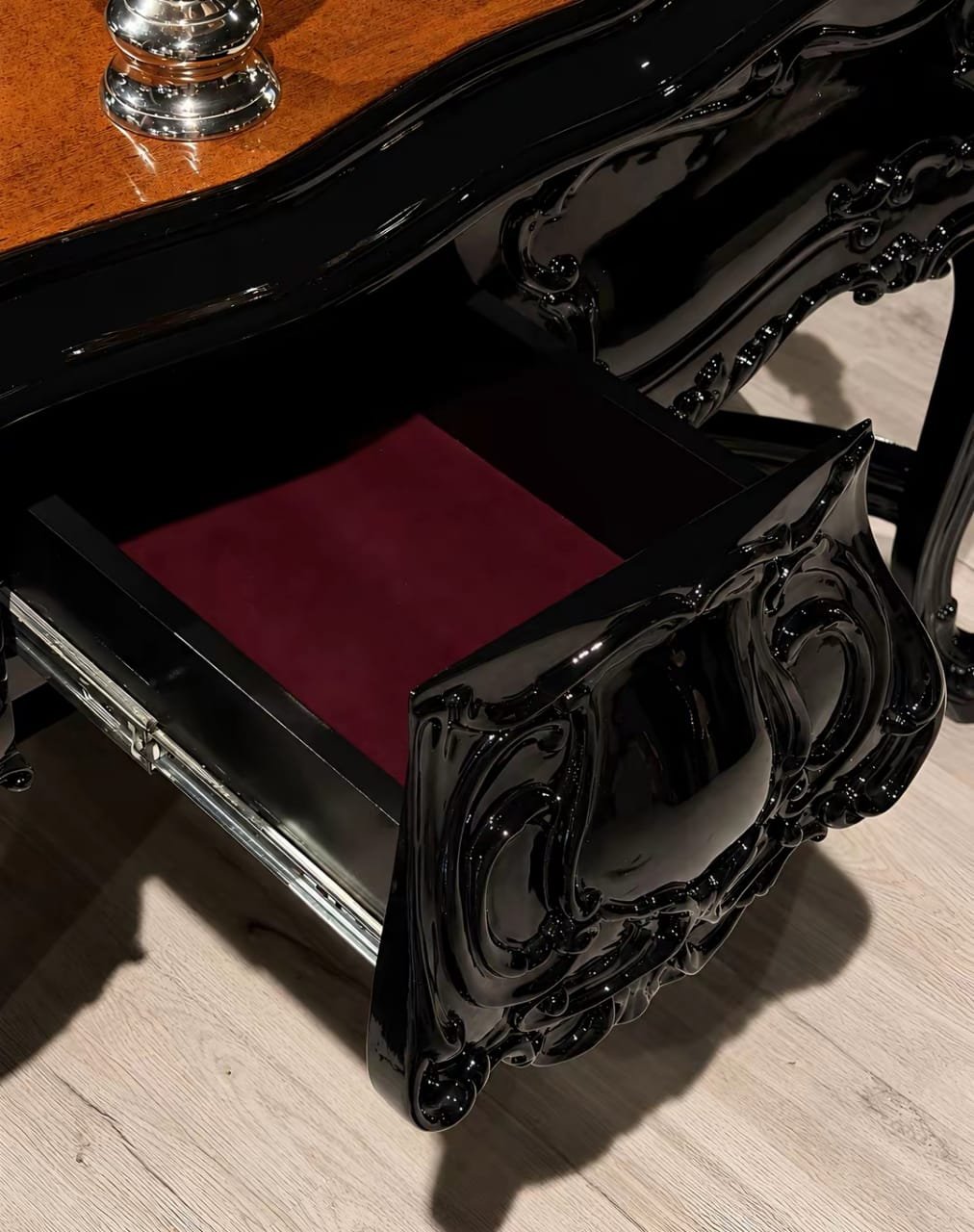 A carved console drawer, open to show the finish inside